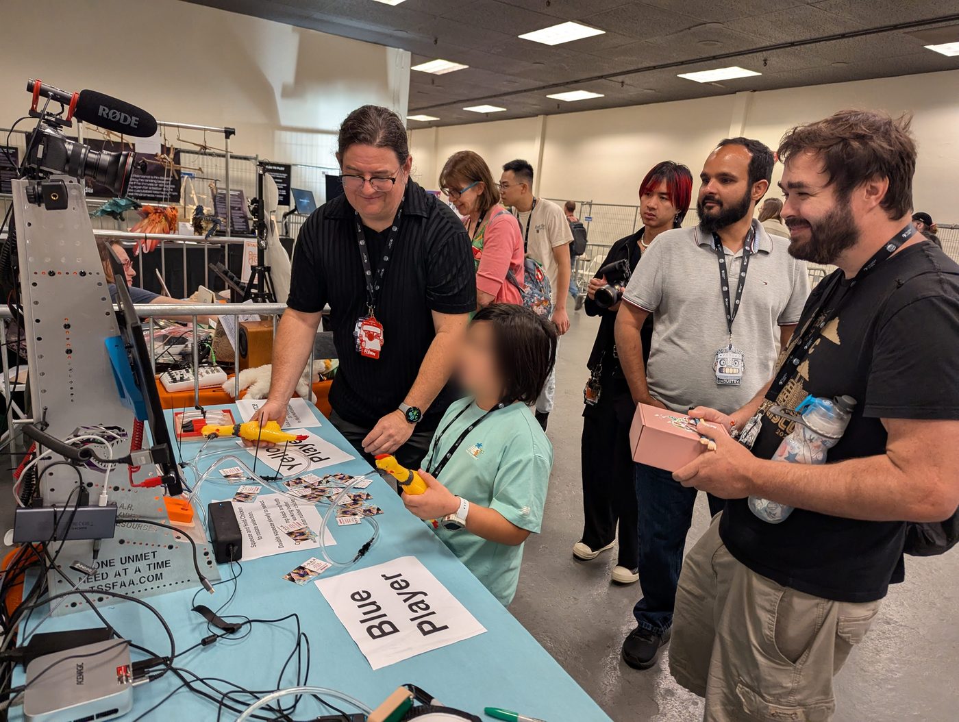 T-Rex demonstrating an assistive device to visitors at a booth