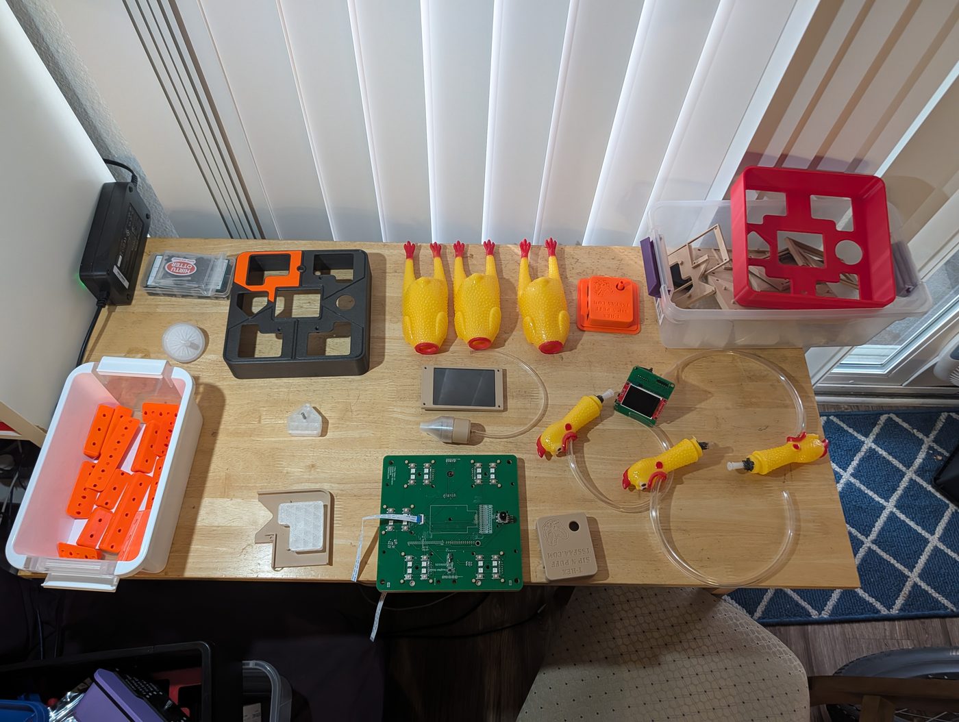Sip-and-puff input device and orange 3D-printed T-Rex enclosures on a bench