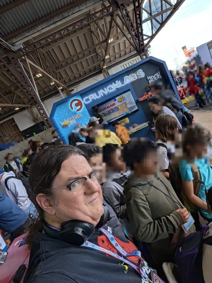 T-Rex in the crowd at Bay Area Maker Faire 2026 on Mare Island, with other visitors blurred